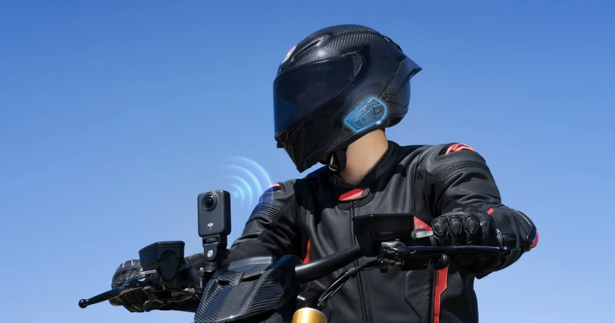 Motocyklista w kasku z kamerą 360 DJI Osmo 360 zamocowaną przy kierownicy motocykla